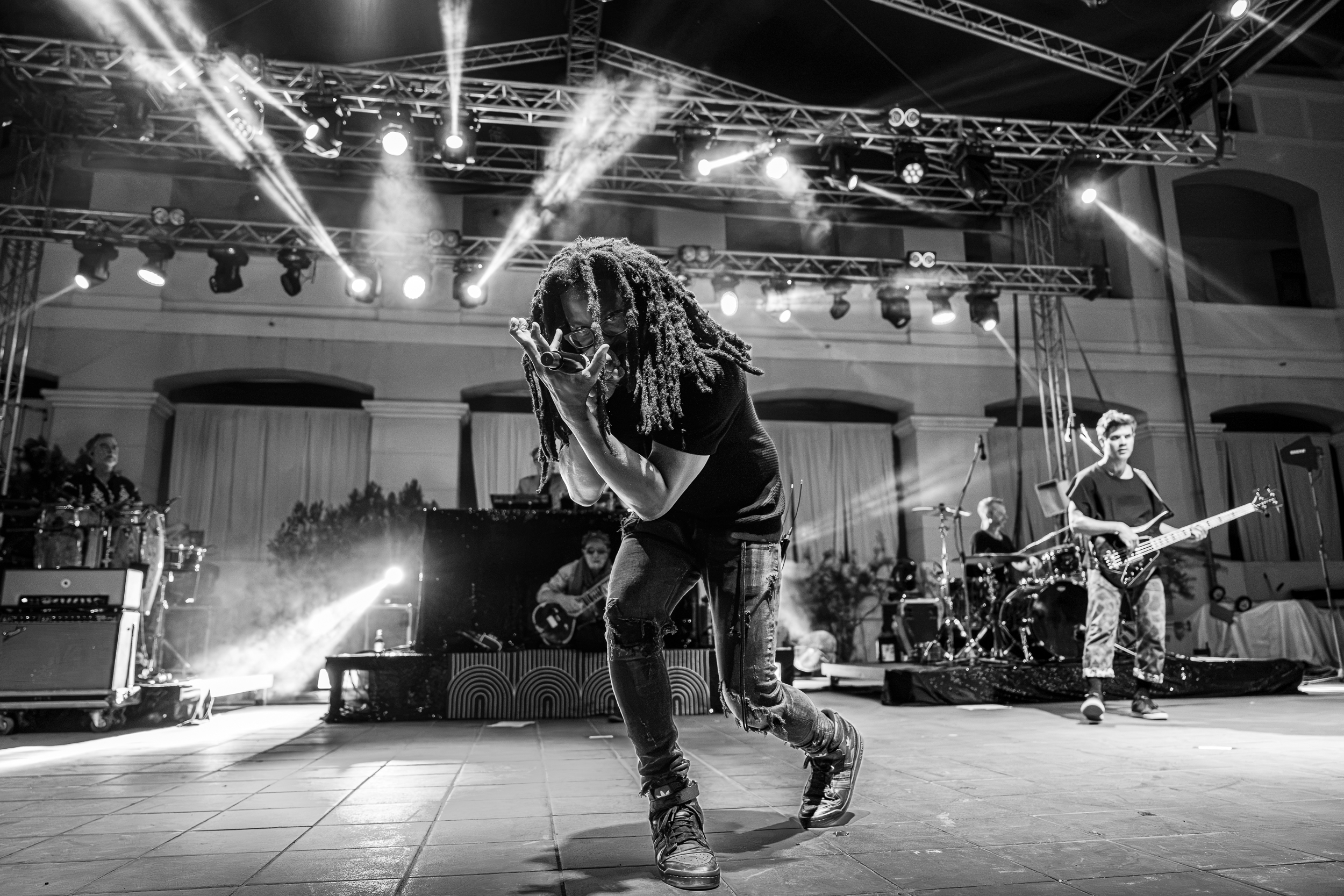Mr. Lif performing with Thievery Corporation at Moni Lazariston in Thessaloniki, with the band behind him on stage.