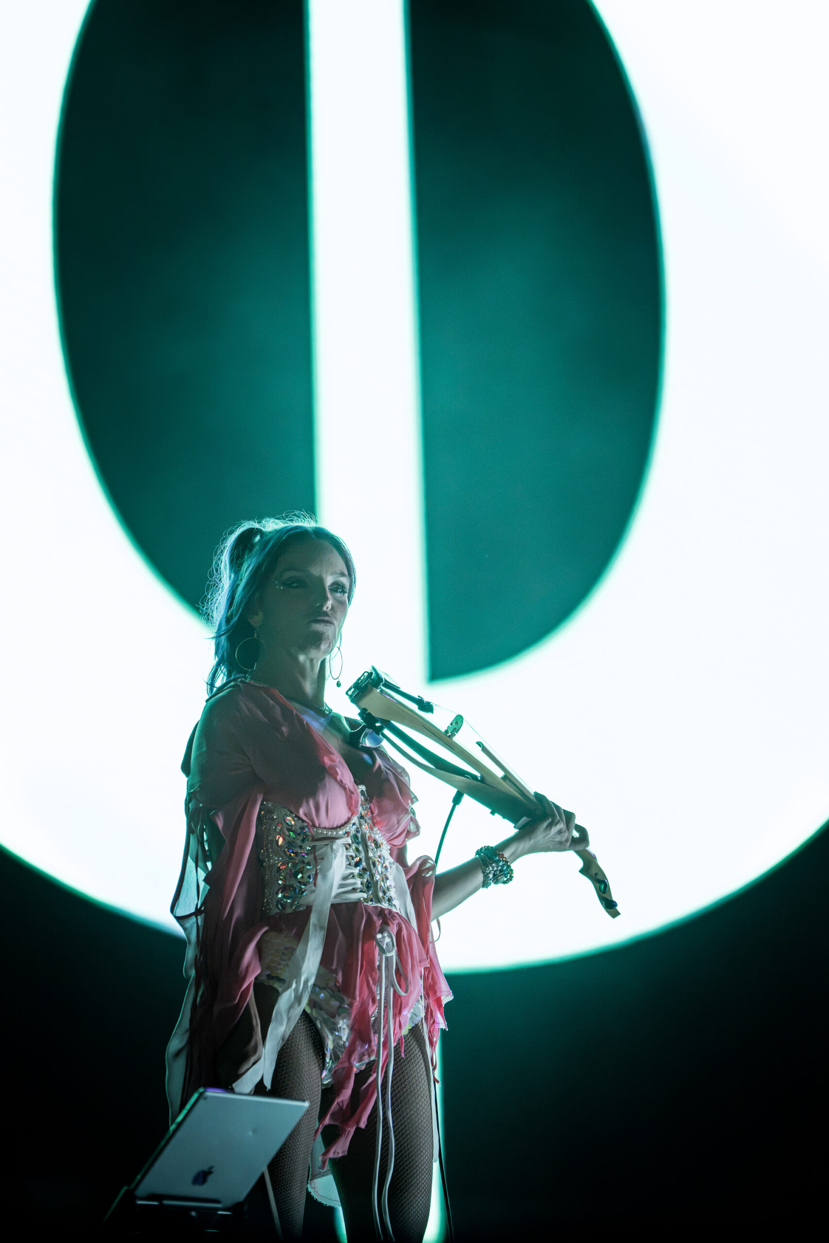 Andrea Whitt playing violin with Moby’s band at Release Athens Festival 2026, surrounded by dramatic stage lighting and large visual projections.