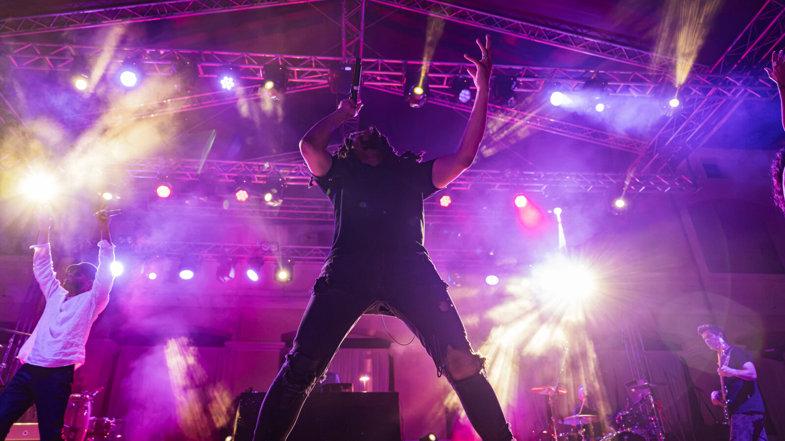Thievery Corporation performing live at Moni Lazariston in Thessaloniki under colorful stage lights.