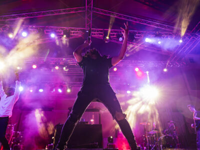 Thievery Corporation performing live at Moni Lazariston in Thessaloniki under colorful stage lights.