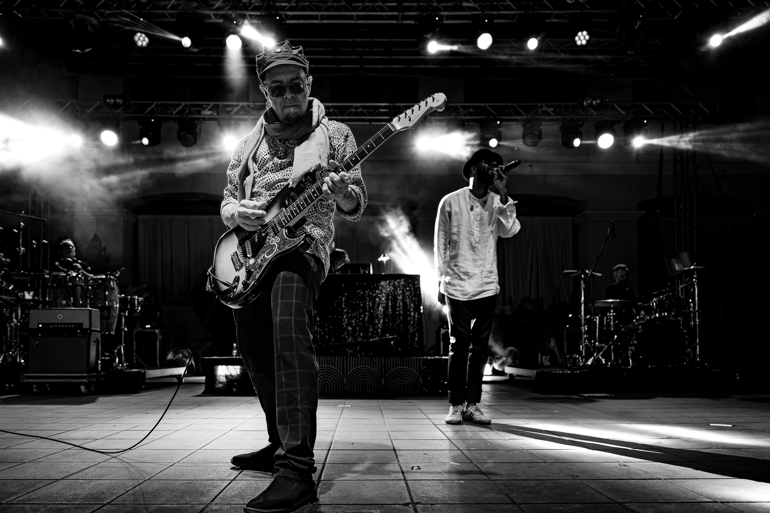 Rob Myers playing guitar with Thievery Corporation at Moni Lazariston in Thessaloniki, with Puma Ptah performing behind him.
