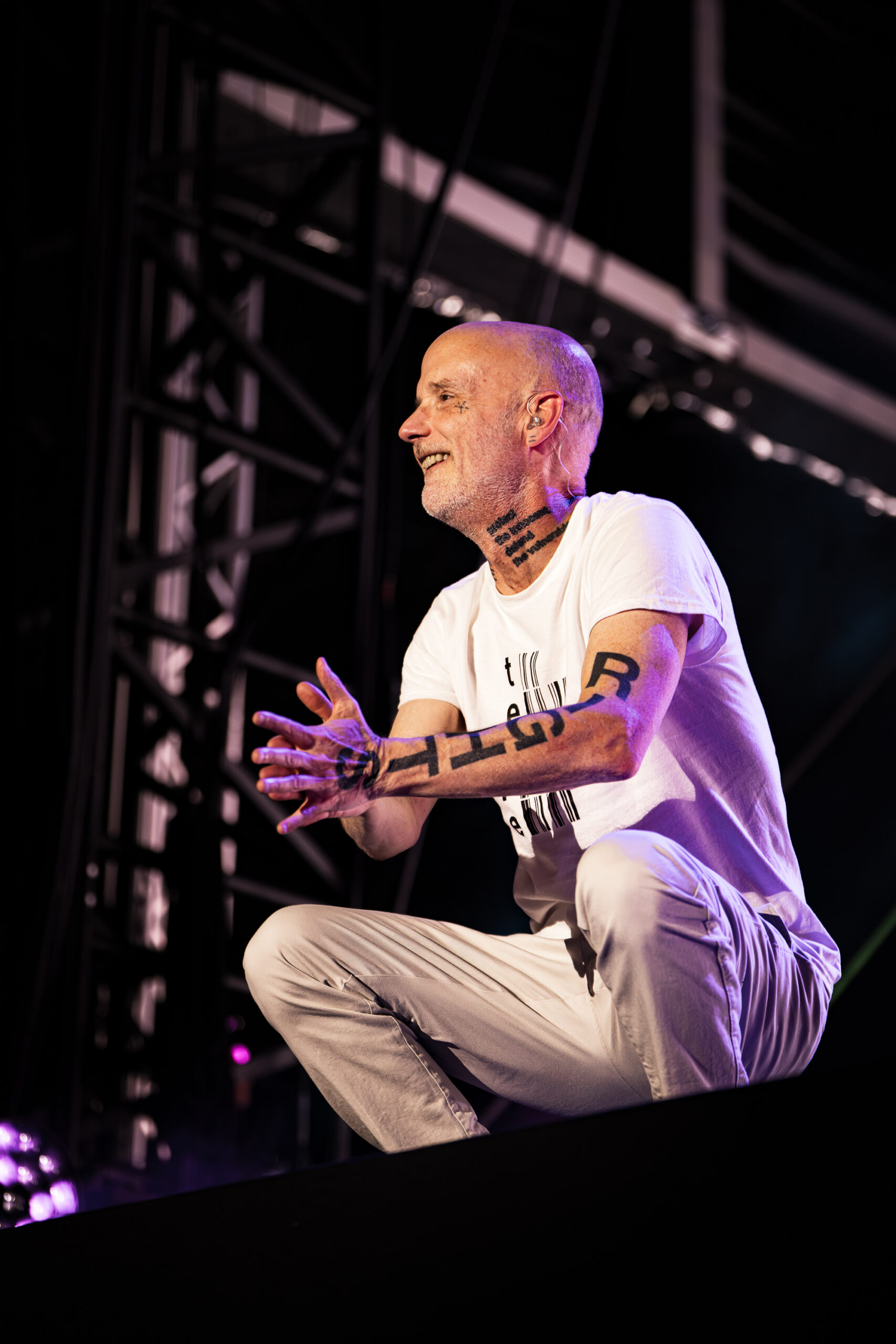 Moby performing live on stage at Release Athens Festival 2026, standing under purple and blue lights with colorful stage visuals in the background