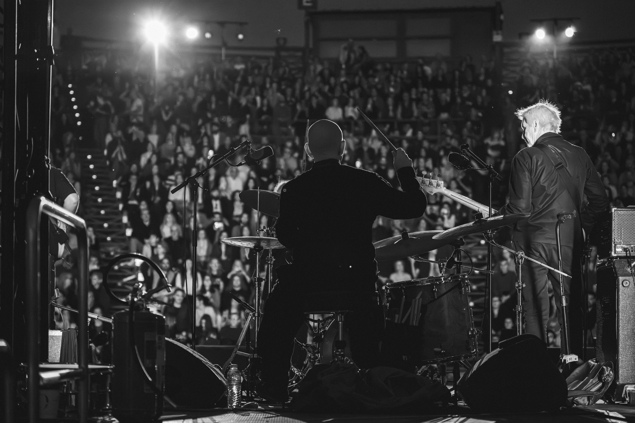 Seb Rochford on drums and Tony Shanahan on bass performing in front of the audience during the Patti Smith Quartet concert at Lycabettus Theater, Athens, 2026