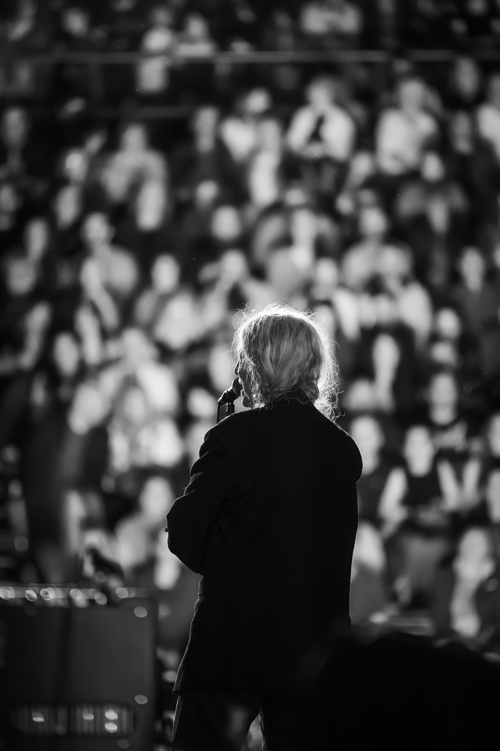 Black-and-white photo of Patti Smith seen from behind, facing the crowd at Lycabettus Theater during her Athens concert in 2026
