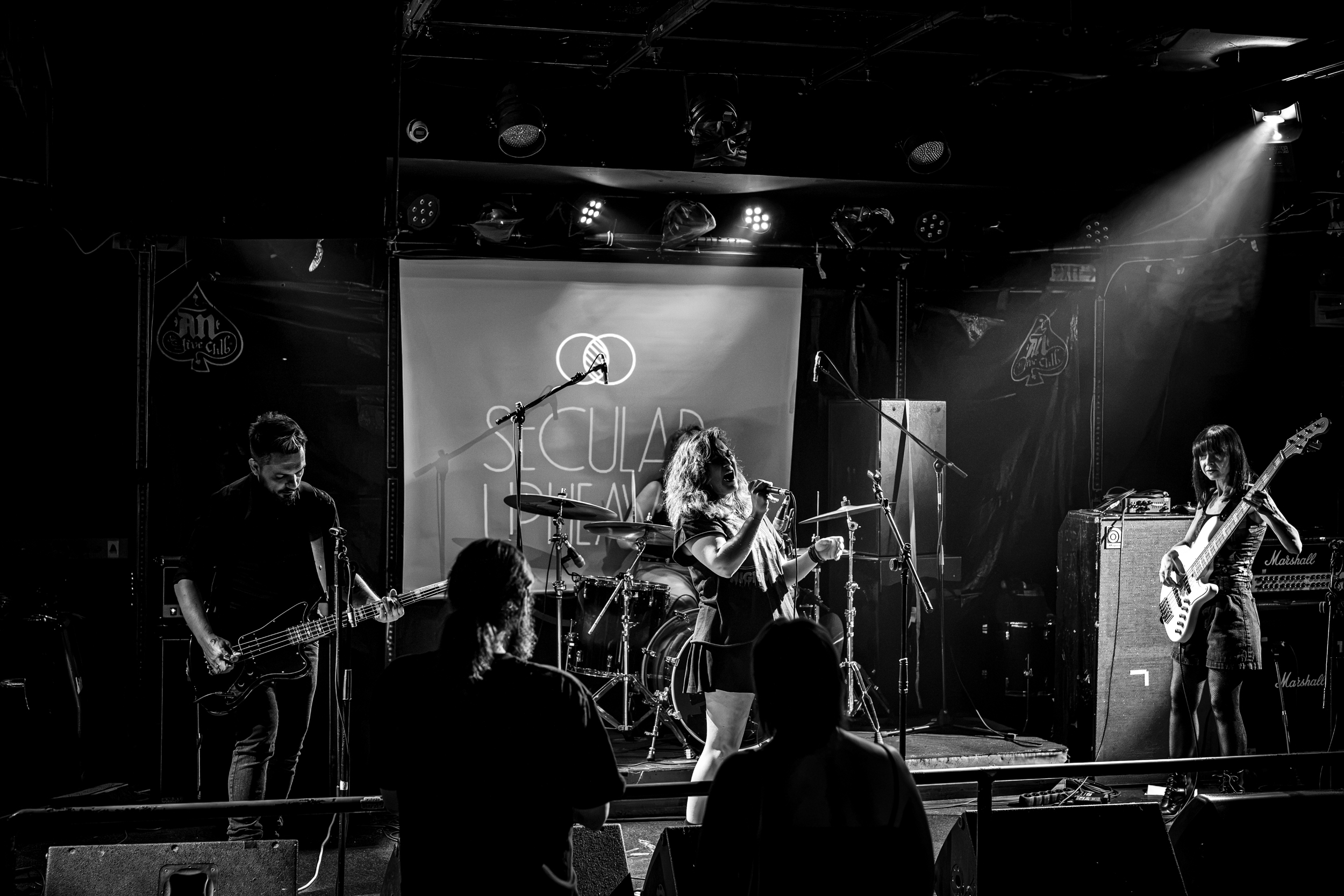 Secular Upheaval performing live at AN Club in Athens in 2026, with vocals, two bass guitars and drums.